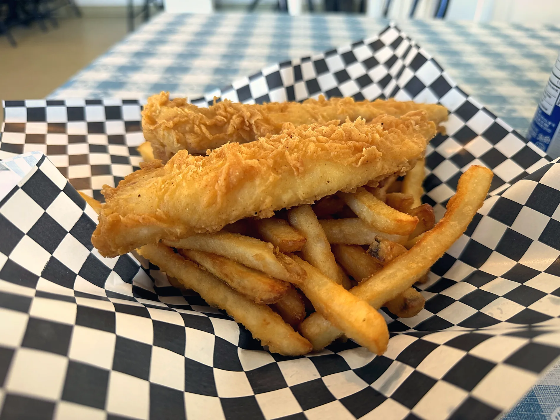 Fresh fish and chips in a checkered paper basket